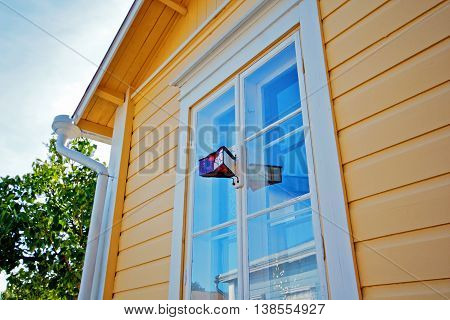 Window of country house. A vintage device for monitoring the street.