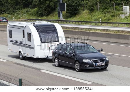FRANKFURT GERMANY - JULY 12 2016: Volkswagen Passat Estate family car towing a caravan on the highway in Germany