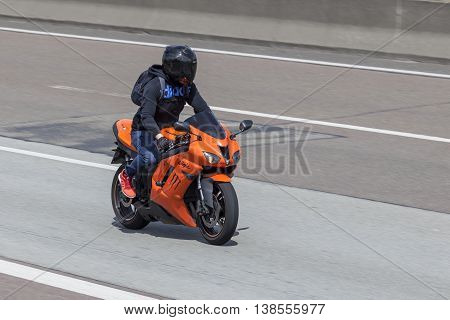 FRANKFURT GERMANY - JULY 12 2016: Motorcyclist on the orange Kawasaki Ninja ZX-6R motorcycle driving on the highway in Germany