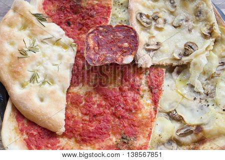 slices of homemade assorted pizza and soppressata salami