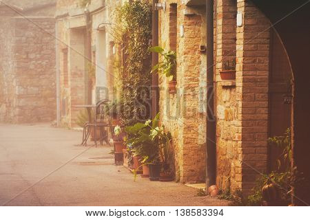 Empty street of small Tuscany town San Quirico d'Orcia in the morning fog, romantic travel vintage hipster european italy background