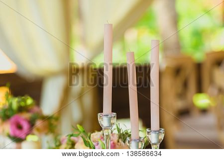 Сandles and flower composition in the restaurant. Wedding dinner