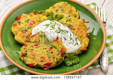 Vegetarian cuisine - vegetable fritters (with potatoes, carrot, zucchini, paprika and parsley).