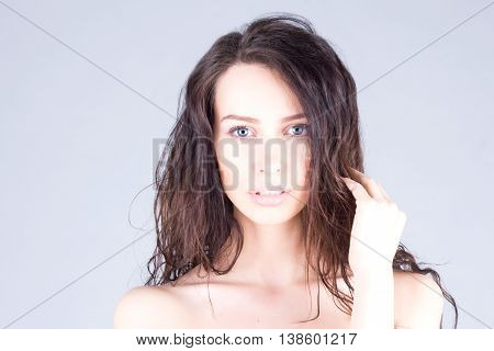 Pretty sexy woman with wavy hair and blue eyes touching her hair. Beauty woman.