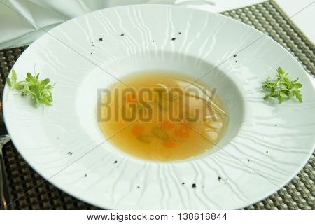 Consomm soup with Vegetable in a white dish