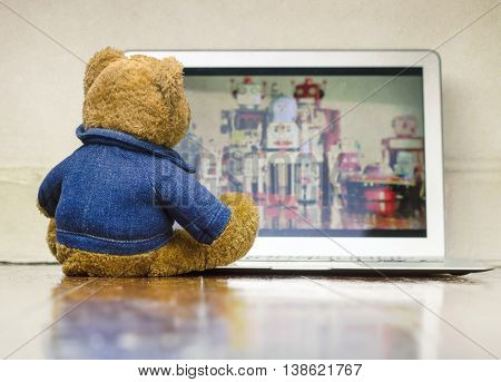 teddy bear watching a film on a laptop computer 
