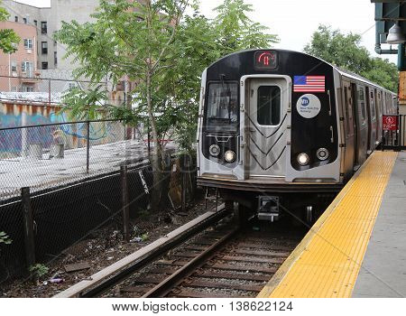 BROOKLYN, NEW YORK - JULY 9, 2016: NYC Subway Q Train arriving at Kings Highway Station in Brooklyn. Owned by the NYC Transit Authority, the subway system has 469 stations in operation
