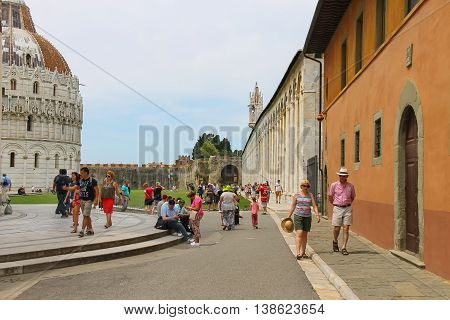Pisa Italy - June 29 2015: Tourists walking on Piazza del Duomo in historic centre. Province Pisa Tuscany region of Italy