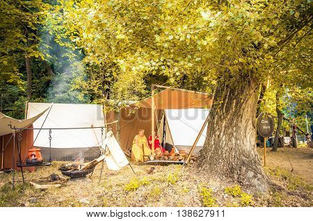 Monterenzio Italy 09 July 2016 - two women rest under a big sequoia tree in the woods during a Celtic historic reenactment