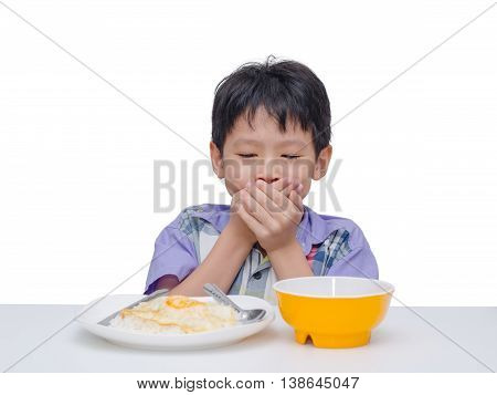 Asian child close his mouth by hand between having lunch