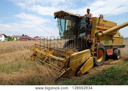 TRNOVEC, CROATIA - JULY 09, 2016: Combine harvester harvest ripe wheat on a farm in Trnovec, Croatia on July 09, 2016