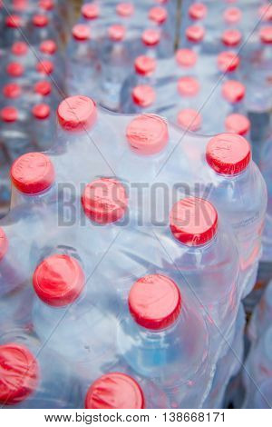 Stacks of red capped water bottles ready to be distributed as a part of a disaster relief effort.