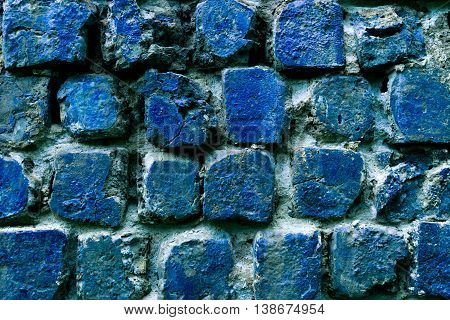 Old corroded wall made from blue slag (Cinder) stones