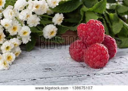 Ripe red raspberry represented on white wooden background. Some raspberries nive idea for any background.