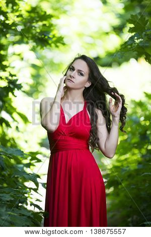 Beautiful young caucasian brunette woman in red dress outdoors expressive portrait