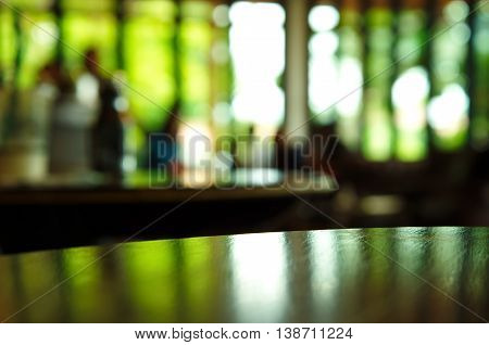 blur green nature light reflection on empthy table in cafe at night background
