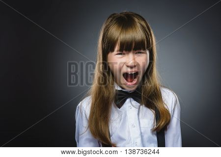 Closeup Portrait of handsome girl with astonished expression while standing against grey background.