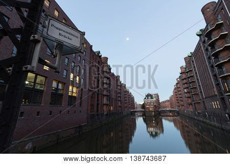 Wasserschloss In Hamburg Speicherstadt With Sign Poggenmuehlenbruecke At Morning, Germany