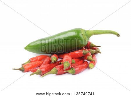 Pile of red italian peppers with a green jalapeno over it, composition isolated over the white background