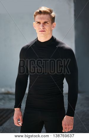 Portrait of male athlete in black clothes