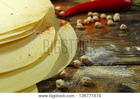 Colorful Indian food - papadum chickpea gram flour and spices on textured wooden table top