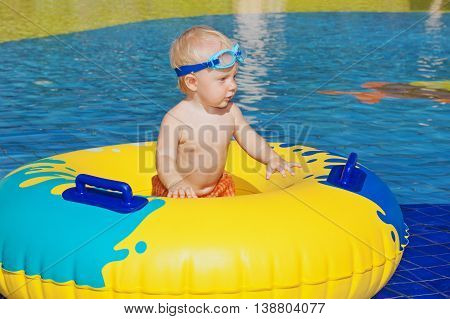 Happy family has a fun in beach pool - baby boy sunbathing swim with inflatable toy. Healthy lifestyle active parent people water sports activity and swimming lesson on summer holiday with child