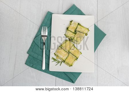 Oven baked courgettes stuffed with cheese garlic and herbs. Courgette recipe in the oven. Top view with copy space.