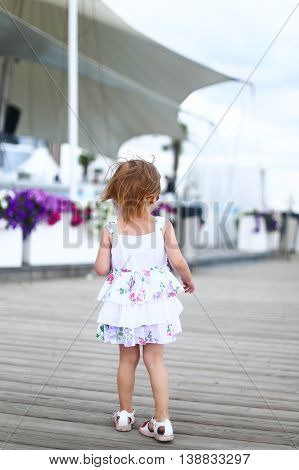 kid walk child walking summer nature childre back dress hair sandals footwear flowers the background