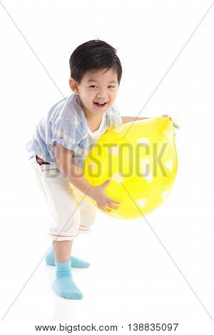 Cute asian boy playing yellow balloon on white background isolated