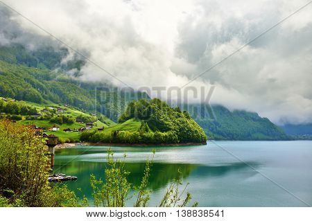 Beautiful emerald mountain lake Lungern in Switzerland under low clouds