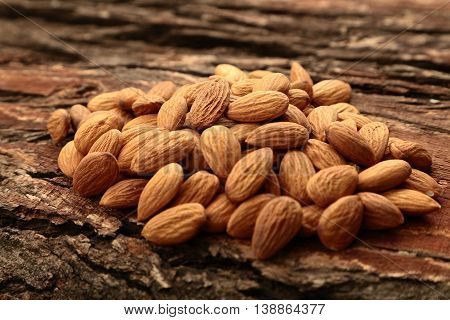 Ripe organic  almonds on dark wooden background