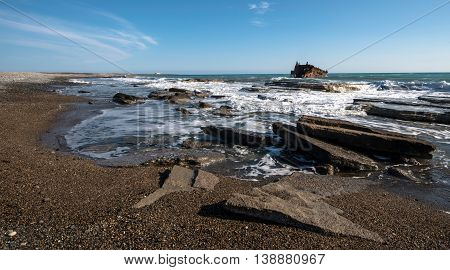 Shipwreck of an abandoned ship on a rocky coast at Akrotiri Beach in Cyprus
