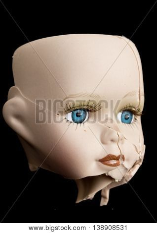 Broken Doll Face and Head on Black Background