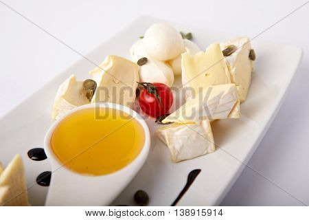 Different kinds of cheese on a white plate