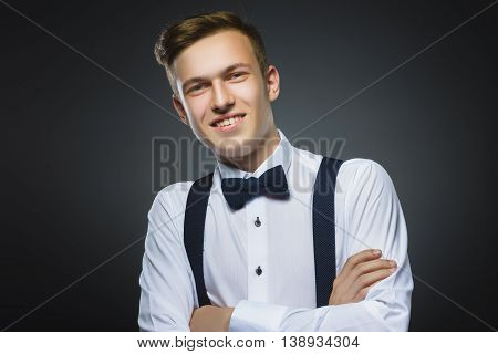 Happy boy. Closeup Portrait of handsome teenager smiling isolated on grey background.