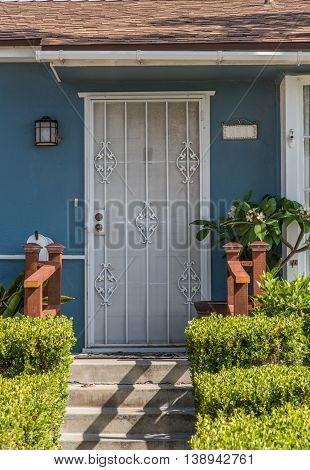 House Entrance Door Behind The Grid And Doorsteps