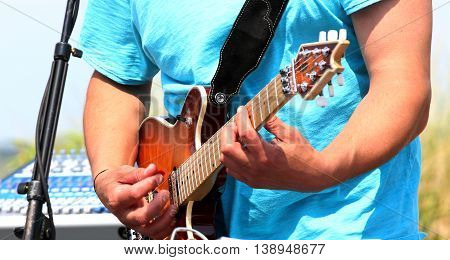 Man playing jamming on his guitar outside