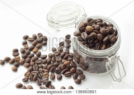 heap of coffee beans isolated on a white background from glass jar