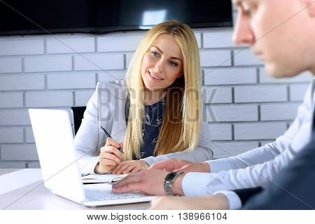 Business colleagues working and analyzing financial figures / graphs on a laptop