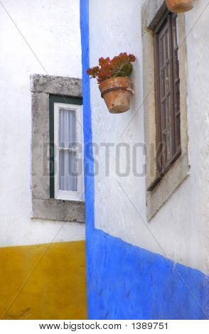 Casas de estilo rústico con maceta en la ventana