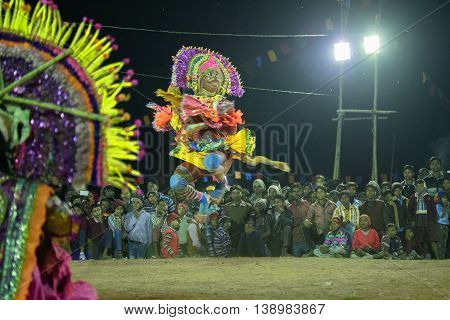BAMNIA PURULIA WEST BENGAL INDIA - DECEMBER 23RD 2015 : Dancer dressed as Hanumanji is jumping on air Chhau Dance festival. It is a very popular Indian tribal martial dance performed at night amongst spectators.