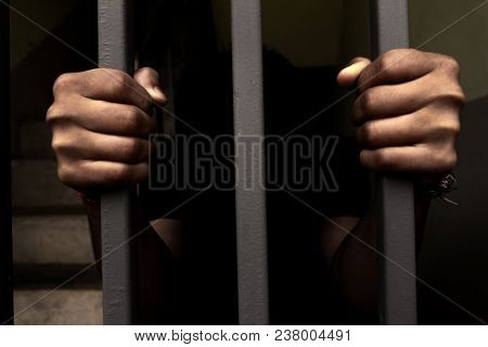 The Hand Of A Prisoner In A Steel Cage.