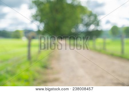 Abstract Backgrounds Image Defocused Background Of Rural Farm Fenced  Dirt Road And Fields.