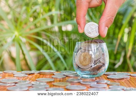 Hand Of  Female Putting Coins In Jar With Money Stack Step Growing Growth Saving Money