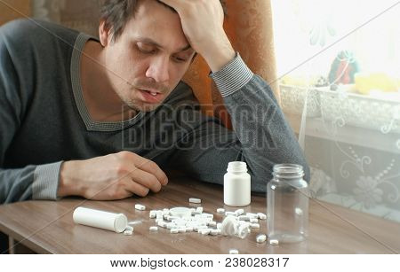Man Has A Lot Of Pills And Falls Asleep. The Concept Of Depression, Suicide And Danger