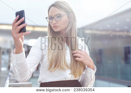 Young Smart Blonde Businesswoman In Eyeglasses Taking Selfie In Business Center, Indoors