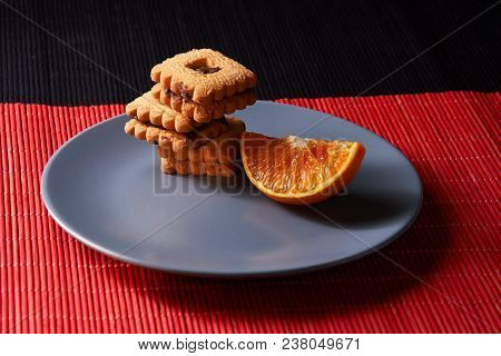Chocolate Chip Cookies And Orange On Gray Plate And On Red With Black Table