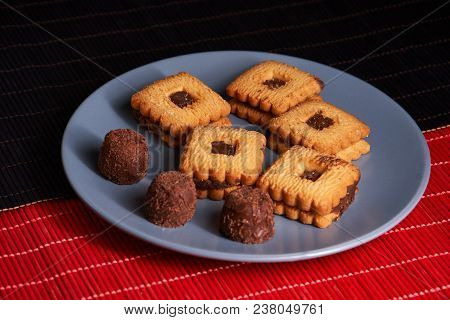Chocolate Cookies On Gray Plate On Red And Black Table