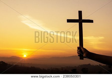 A Human Hand Holding A Crucifix Has A Sunrise As A Background., Concept For Christian, Christianity,