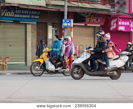Hanoi, Vietnam-december 17, 2013. Women On The Motorolers Drops Their Children To School Early Morni